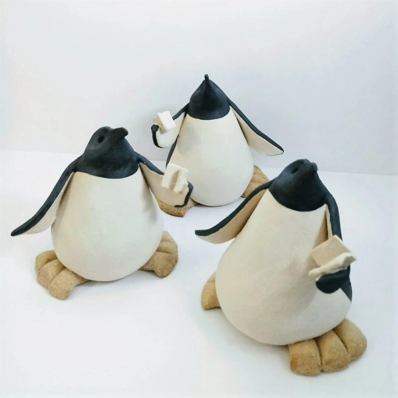 ceramic penguins with books