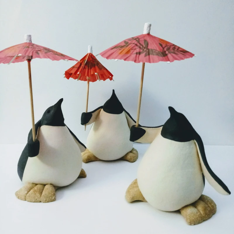 small ceramic penguins holding parasols
